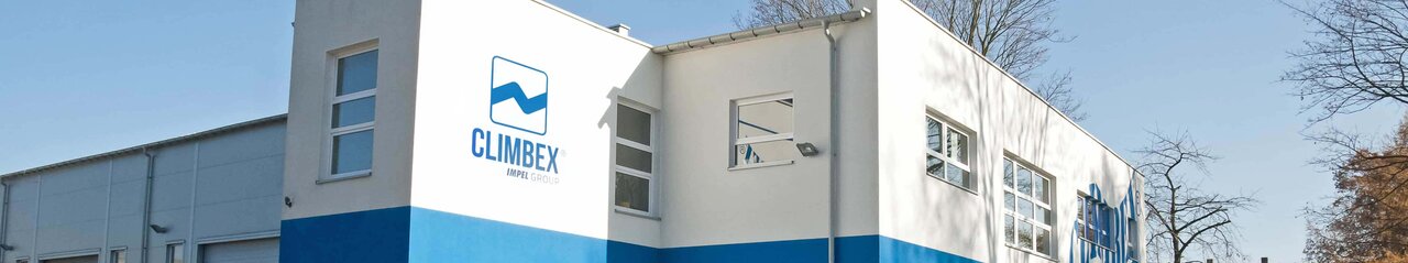 Gezeigt wird das Climbex Polen Gebäude von außen, links an der Wand ist riesig das Climbex-Logo zu und davor stehen verschiedene Autos.